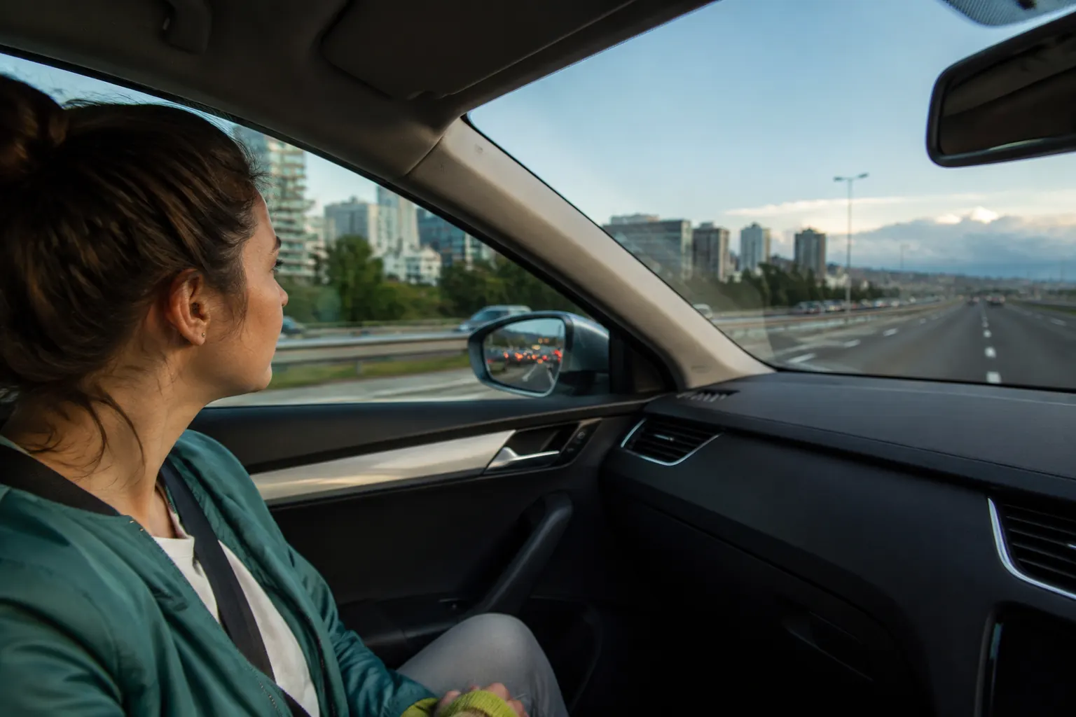 Passenger view as a car leaves stop-start city traffic and joins a steady open highway.
