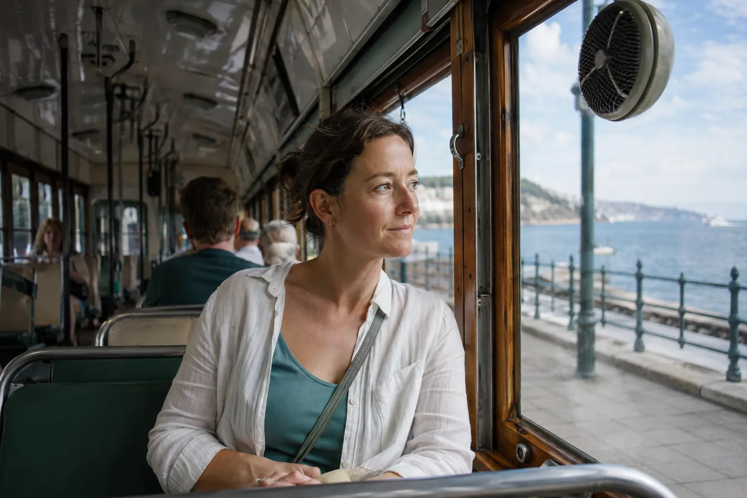 Adult easing back into travel on a short tram ride with a clear forward view and water.