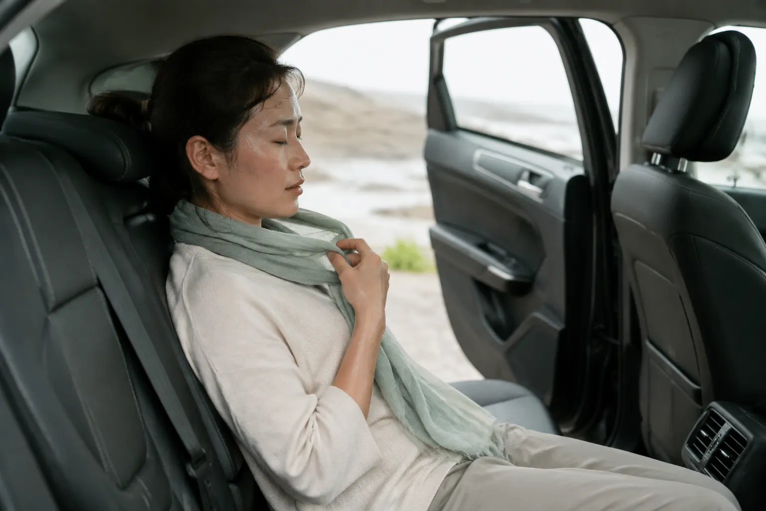 Clammy car passenger cooling down beside an open door during a safe roadside stop.