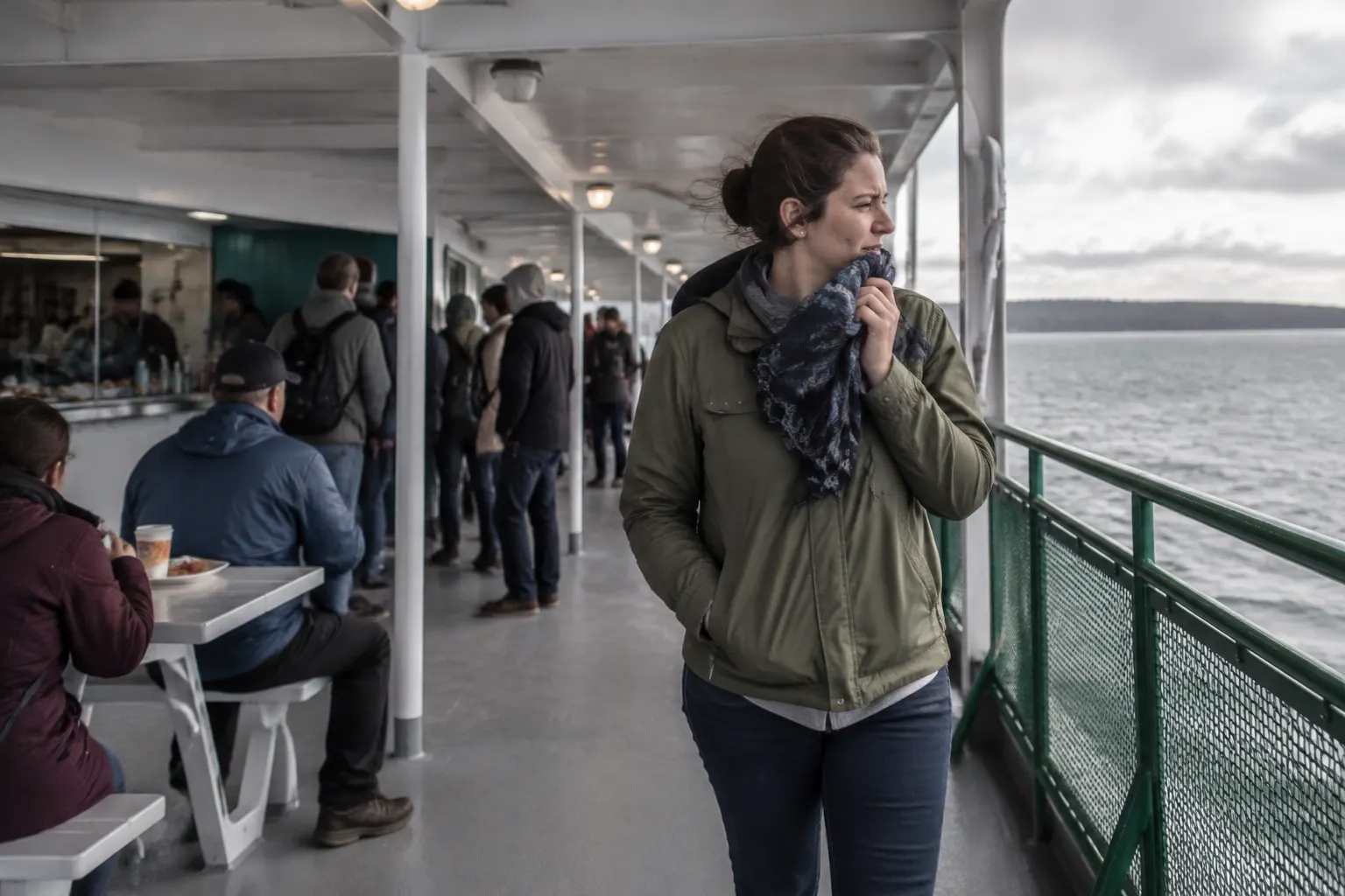 Ferry passenger moving from a food area toward open air after becoming sensitive to smells.
