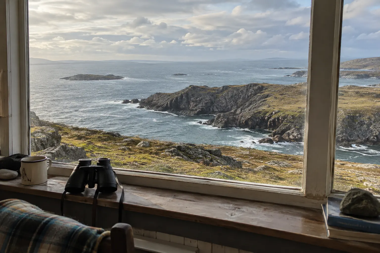 A rugged coastal headland with a sheltered channel opening toward broader sea.