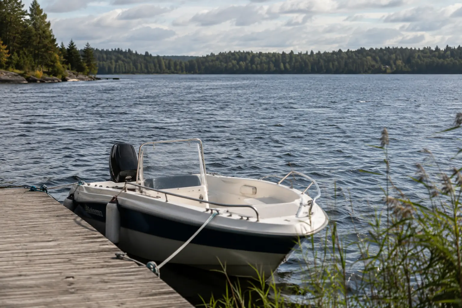 Short wind-driven chop on a broad lake beside a securely moored small boat.
