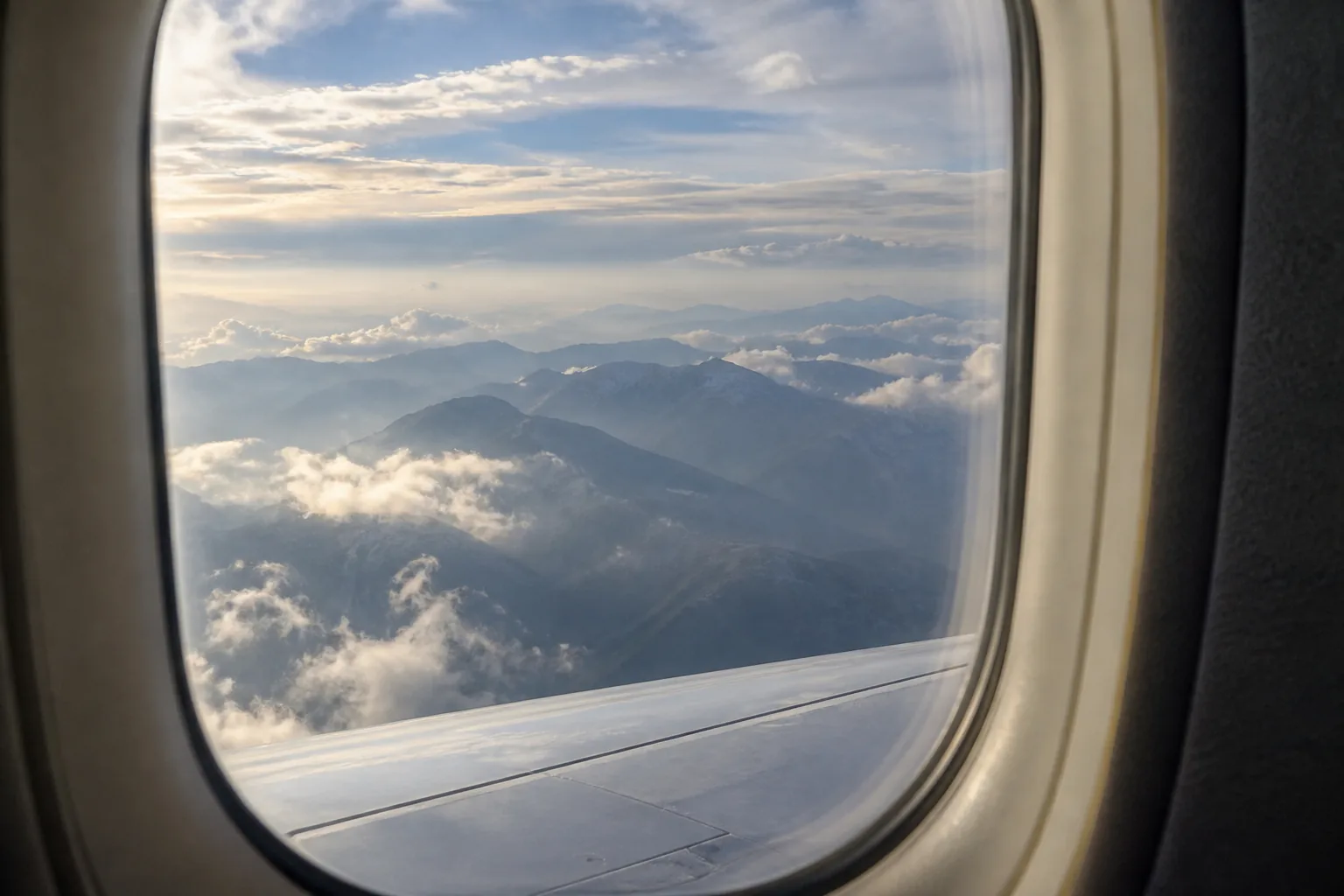 Distant mountain ridges and a level horizon visible through an airliner window.