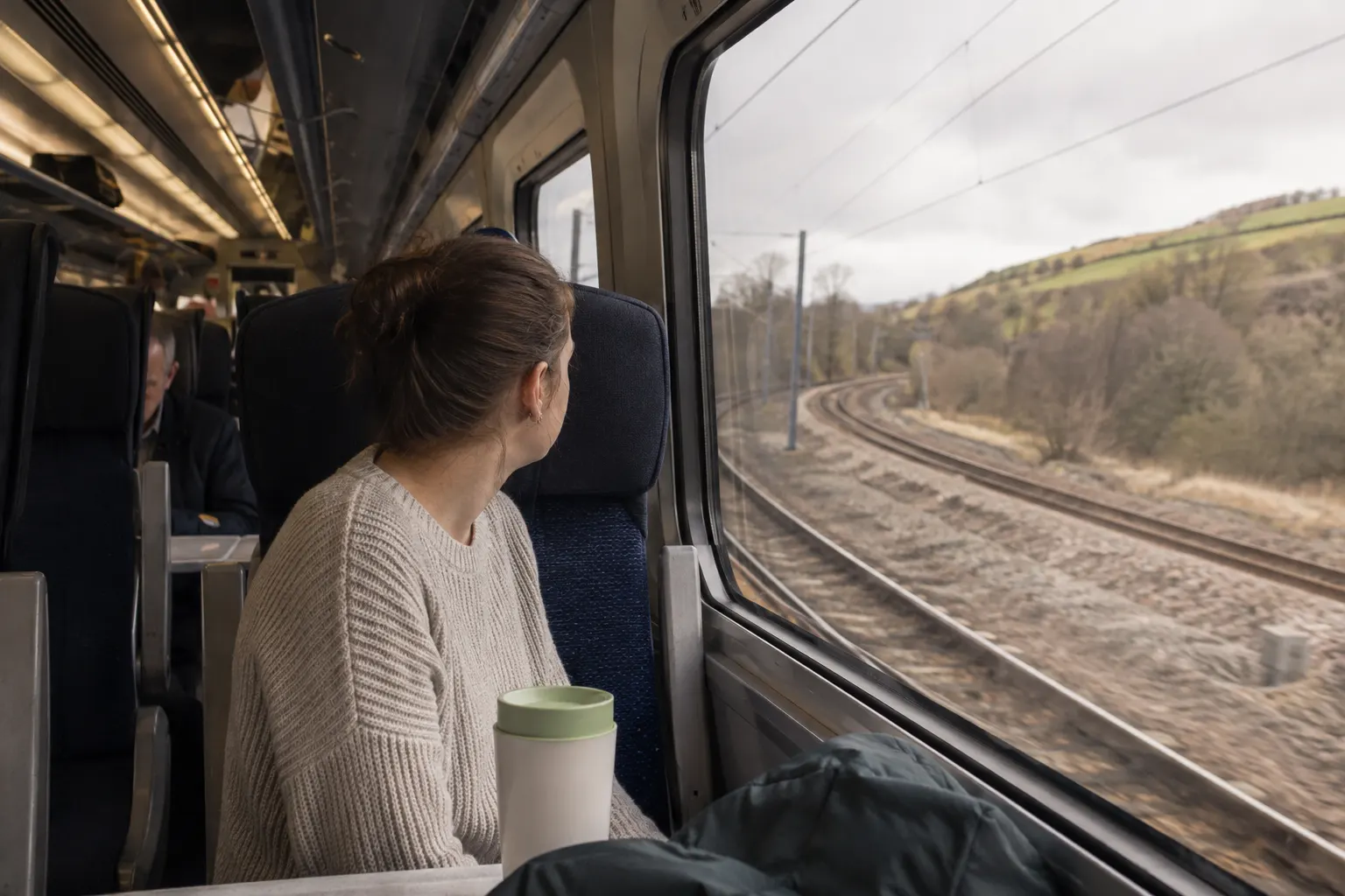 Passenger looking forward through the window inside a subtly tilting intercity train on a curve.